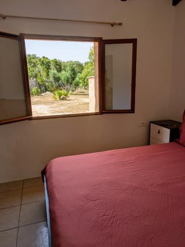 - une chambre avec un lit rouge et une fenêtre dans l'établissement Maison de campagne, à Bonifacio