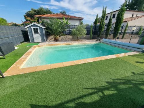 - une piscine dans une cour avec de l'herbe verte dans l'établissement Très belle Villa avec piscine et jaccuzi, à Liouc
