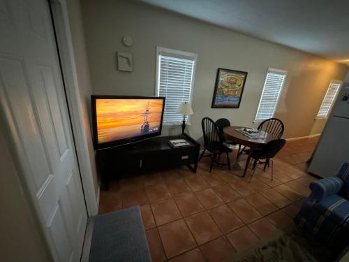 a living room with a television and a table with chairs at Key West Style Historic Home in Coconut Grove Florida, The Blue House in Miami