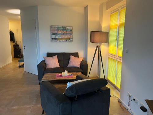 a living room with a couch and a table at Hochwertige Traumferienwohnung Fehmarn - Neue Tiefe Nähe Südstrand in Fehmarn