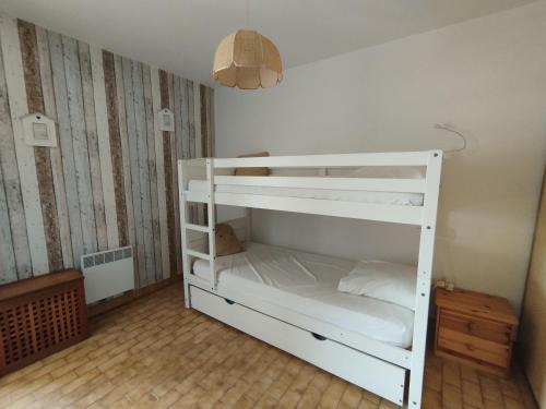 Ce lit superposé blanc se trouve dans un dortoir. dans l'établissement L'effet mer, au Grau-du-Roi