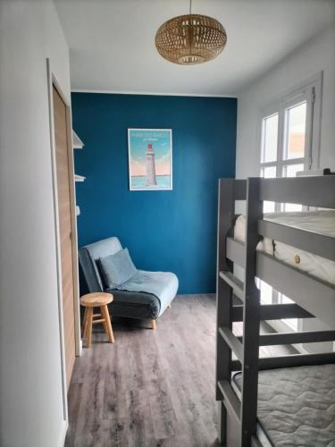 une chambre avec un lit superposé et une chaise dans l'établissement Appartement vue mer, à Les Sables-dʼOlonne