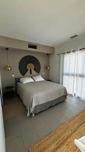 une chambre avec un grand lit et une grande fenêtre dans l'établissement Maison moderne proche plages, à Saleilles