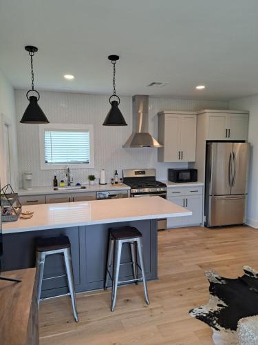 a kitchen with a large island with two bar stools at The Ascension by Kyle in College Station