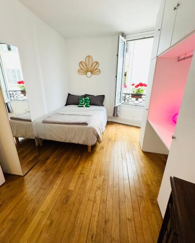 Cette petite chambre comprend un lit et deux fenêtres. dans l'établissement Bel appart proche Tour Eiffel, à Paris