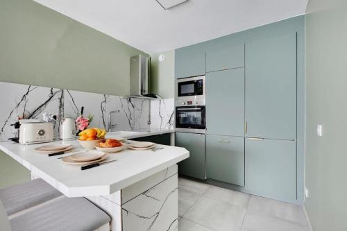 cocina con encimera blanca y armarios azules en ParisCharm, en Pantin