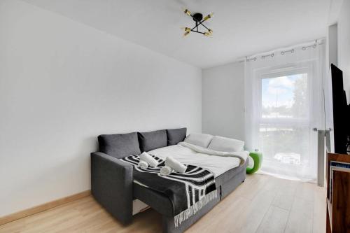 un salon avec un canapé et une fenêtre dans l'établissement ParisCharm, à Pantin