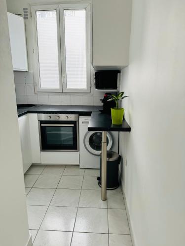 une cuisine avec des armoires blanches et un comptoir noir dans l'établissement Bel appart proche Tour Eiffel, à Paris