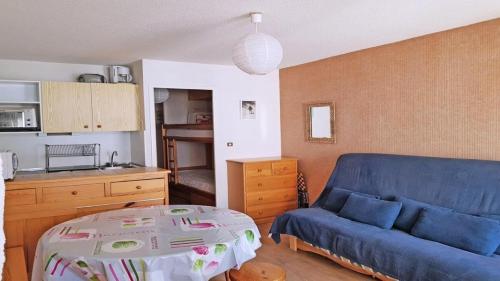 un salon avec un canapé bleu et une table dans l'établissement Résidence Pendine 2 - P2107 - Grand studio - 5 personnes - Front de neige MAE-2524, à Les Prés