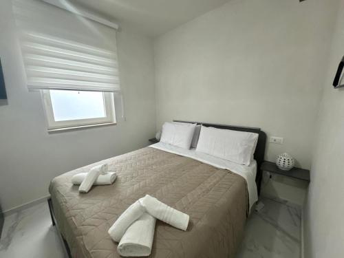 a white bedroom with a bed with towels on it at Casa MarFe in Grottaglie