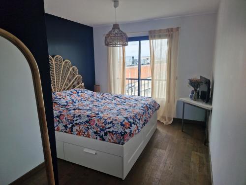 - une chambre avec un lit avec une couette à fleurs et une fenêtre dans l'établissement 100m2 avec terrasse et garage, à Bordeaux