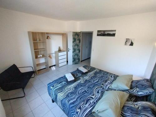 une chambre avec un lit et une chaise dedans dans l'établissement Le Far Niente - Piscine Privée, à Orange