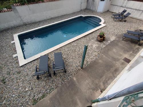 - une vue sur la piscine et ses 2 chaises dans l'établissement Le Far Niente - Piscine Privée, à Orange