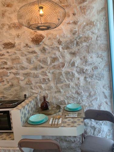 a stone wall with a table with plates on it at Amor Fati in Amfilochía