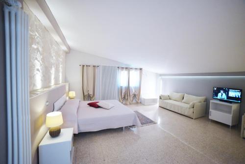 1 dormitorio con cama, sofá y TV en Agriturismo Nonna Rosa en Matera