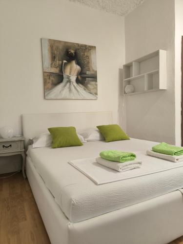 a white bed in a room with a painting on the wall at Apartman Zora in Neum