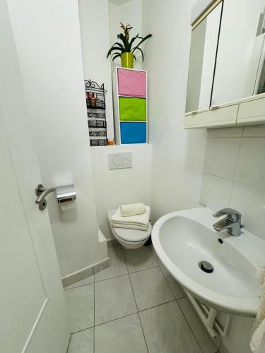une salle de bain blanche avec des toilettes et un lavabo dans l'établissement Bel appart proche Tour Eiffel, à Paris
