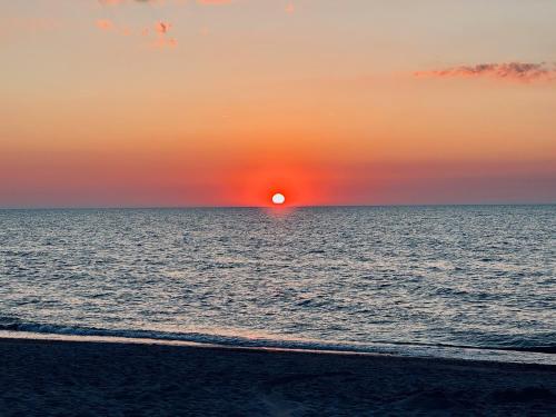 un tramonto sull'oceano con una spiaggia di Willa Marlin a Pobierowo
