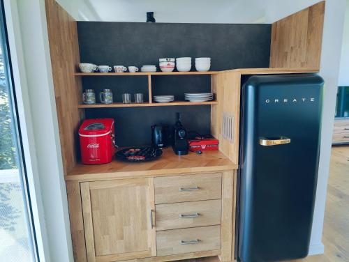 a kitchen with a black refrigerator in a room at Penthouse am Golfplatz, Nähe RedBull Ring in Trofaiach