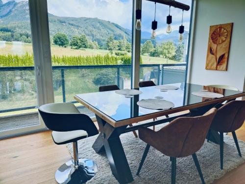 a dining room with a table and chairs and a large window at Penthouse am Golfplatz, Nähe RedBull Ring in Trofaiach