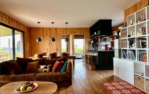 un salon avec un canapé et une table dans l'établissement Maison bois avec vue lac Piscine, à Teillet