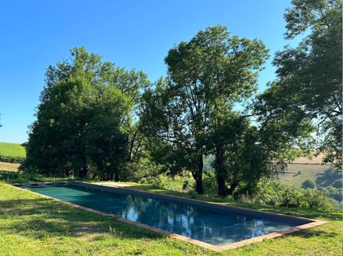 une piscine au milieu d'un champ avec des arbres dans l'établissement Maison bois avec vue lac Piscine, à Teillet