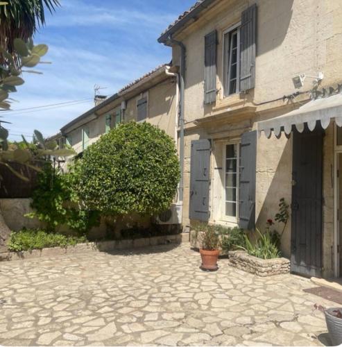 une maison avec une allée en pierre en face de celle-ci dans l'établissement Chambres privées dans Maison en Provence, à Fontvieille
