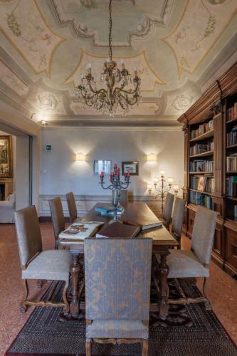 a dining room with a table and chairs and a chandelier at Hotel Villa Sermolli in Borgo a Buggiano