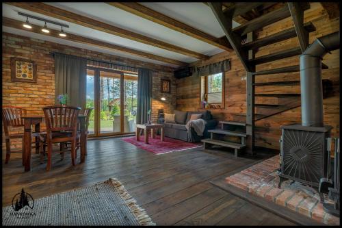a living room with a fireplace in a log cabin at Hankówka Mazury in Jerutki