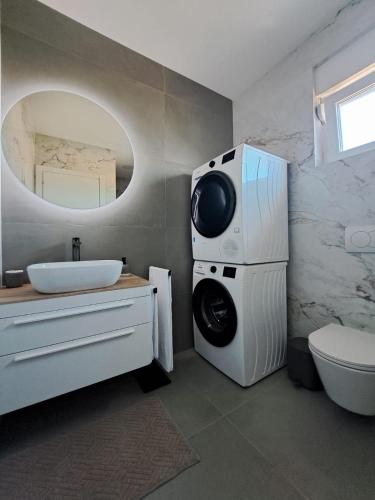 a bathroom with a sink and a toilet and a mirror at Villa Mare Pirovac in Pirovac