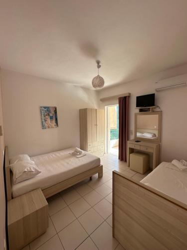 a hotel room with two beds and a television at Elysian Sunset Studios in Himare
