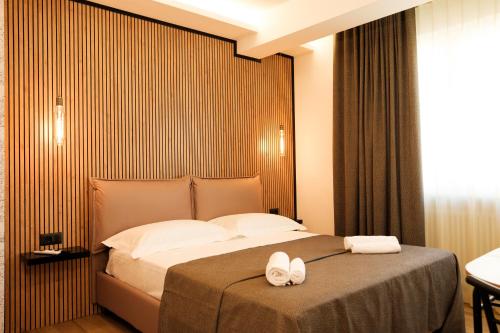 a bedroom with a bed with two white towels on it at Mazzini House B&B in Sassari