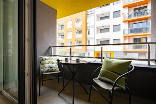 a balcony with a table and chairs and a building at WestSide Garden Apartments by FirstHost in Budapest