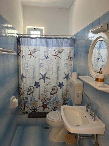 a bathroom with a toilet and a shower curtain at 9 Muses Villas in Chrani