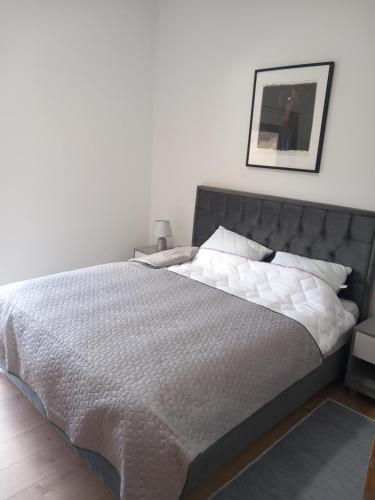 een slaapkamer met een groot bed met een grijs hoofdeinde bij Sarajevo Hills,small villa with garden and garage,OLD CITY in Sarajevo