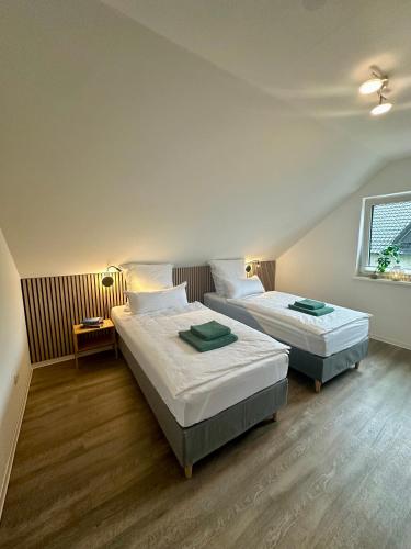 a bedroom with two beds and a window at Familie oder beruflich - 2 Schlafzimmer - 3 Betten - Geräumig - Küche - Gemütlich in Bad Lippspringe