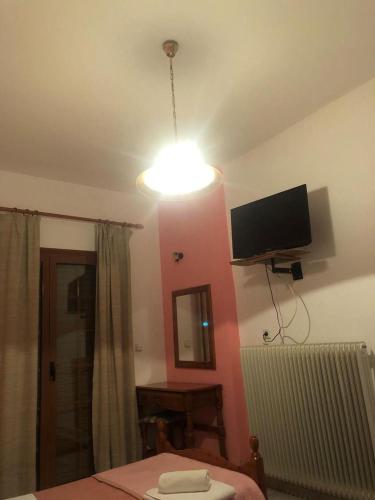 a room with a bed and a tv on the wall at Villa Rea in Melissópetra