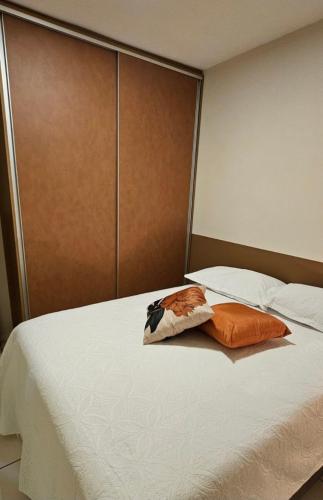 a bed with two pillows sitting on top of it at JM03 Apartamento com Ar Condicionado e Garagem in Dourados