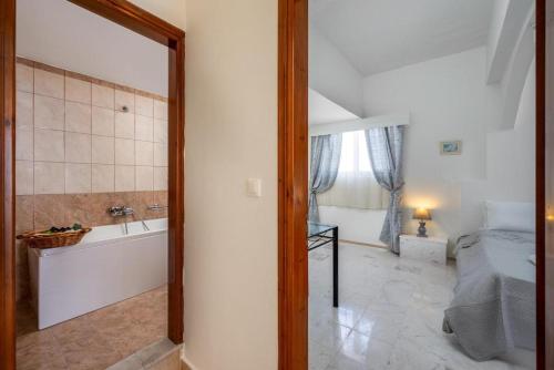 a bathroom with a tub and a bedroom with a bed and a bath tub at Exquisite Retreat For Two in Archangelos