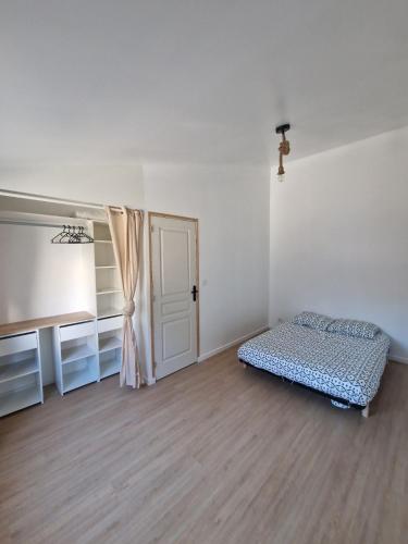 Cette chambre blanche dispose d'un lit et d'une porte. dans l'établissement Maison chaleureuse et élégante, à La Roche-sur-Yon