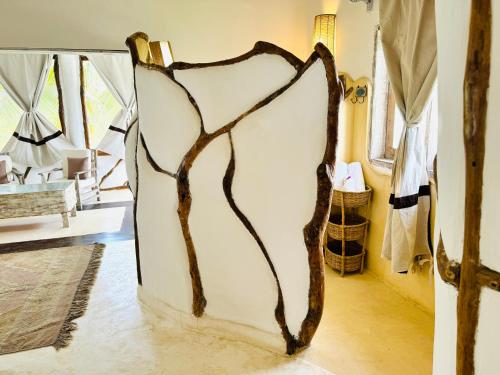 a glass door with a branch design on it in a room at Dream Luxury B&b Watamu in Watamu