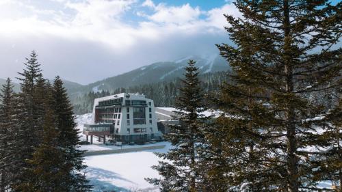 a building in the middle of a snow covered mountain at Aparthotel Phoenix in Bjelašnica