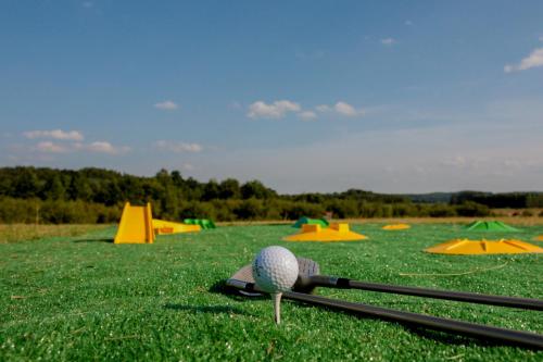 a golf ball and clubs on a green field at Domek Jozef z prywatnym duzym Jacuzzi i sauna Przystan pod niebem in Leczyce