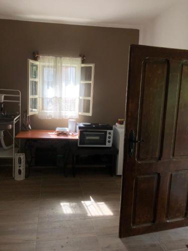 a kitchen with a table with a microwave and a window at Cica Vintage Eco House Near Lake in Crkvine