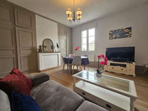 a living room with a couch and a table at T2 Ctre ville Fibre Literie Emma in Montrichard