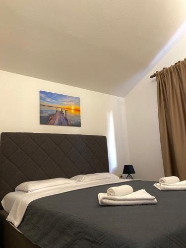 a bedroom with a bed with two towels on it at Apartments Stegic in Tivat