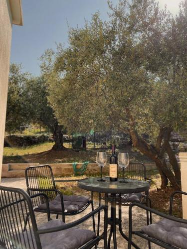 a table with two glasses of wine on a patio at Apartments Stegic in Tivat