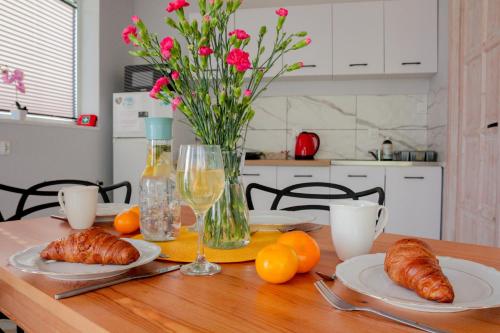 a dining room table with croissants and oranges on it at Domek Jozef z prywatnym duzym Jacuzzi i sauna Przystan pod niebem in Leczyce