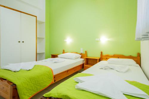 two beds in a room with green walls at Kyprianos in Keri