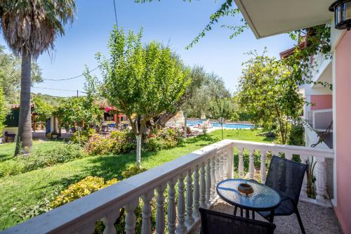 a table and chairs on a balcony with a yard at Kyprianos in Keri